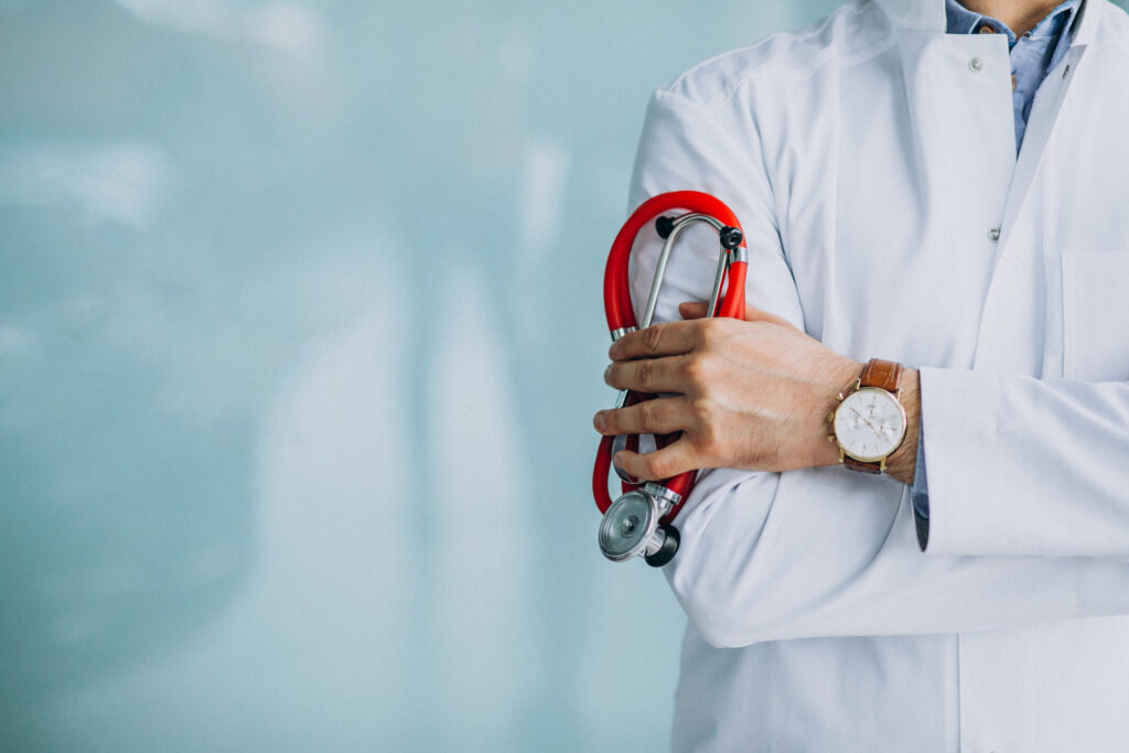 Young handsome physician in a medical robe with stethoscope
